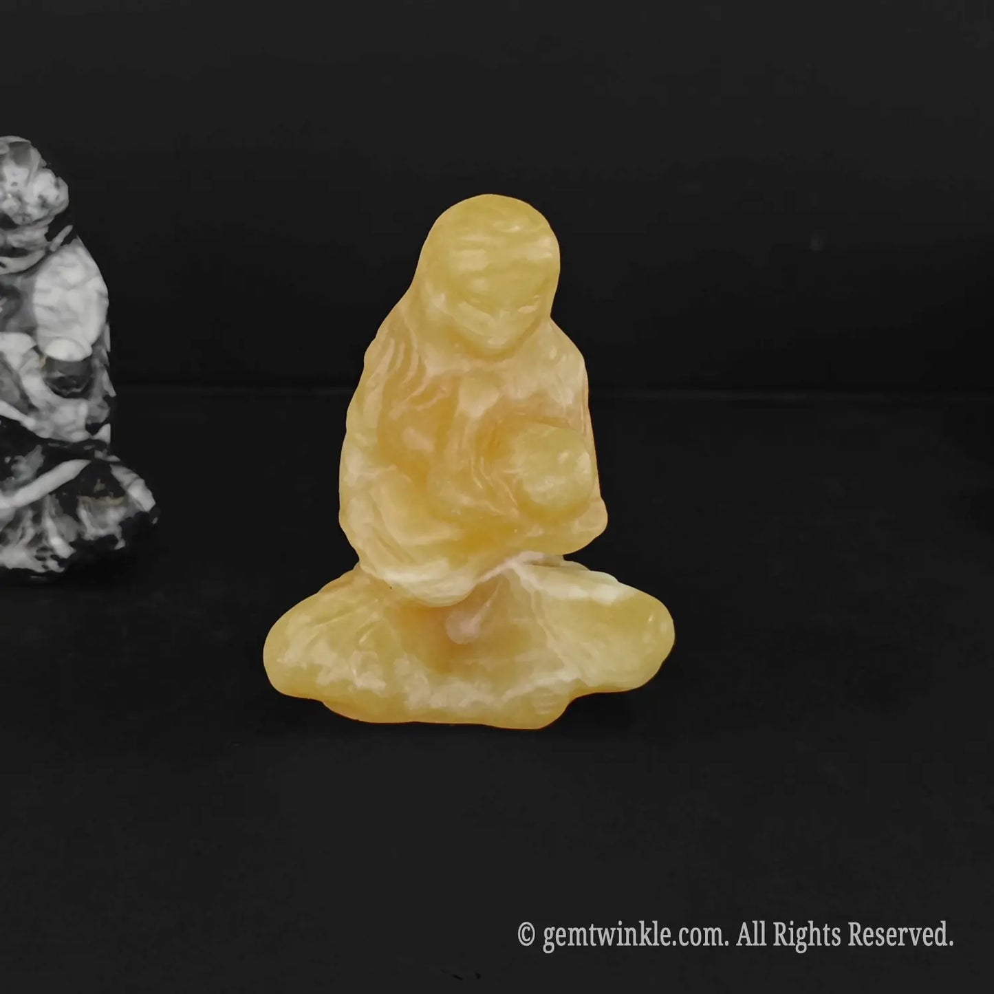 front view of a warm golden yellow calcite madonna holding infant jesus crystal totem