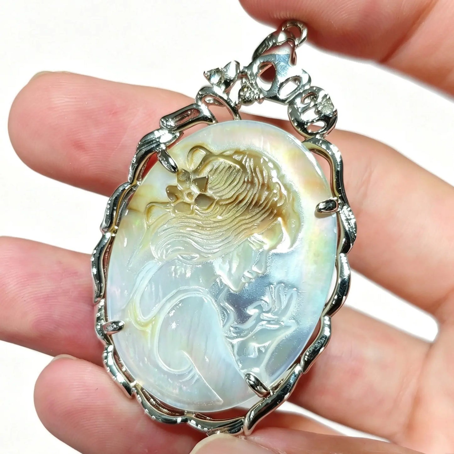 Pendant preview of silver framed gray shell cameo showing carved maiden profile and pearlescent reflections