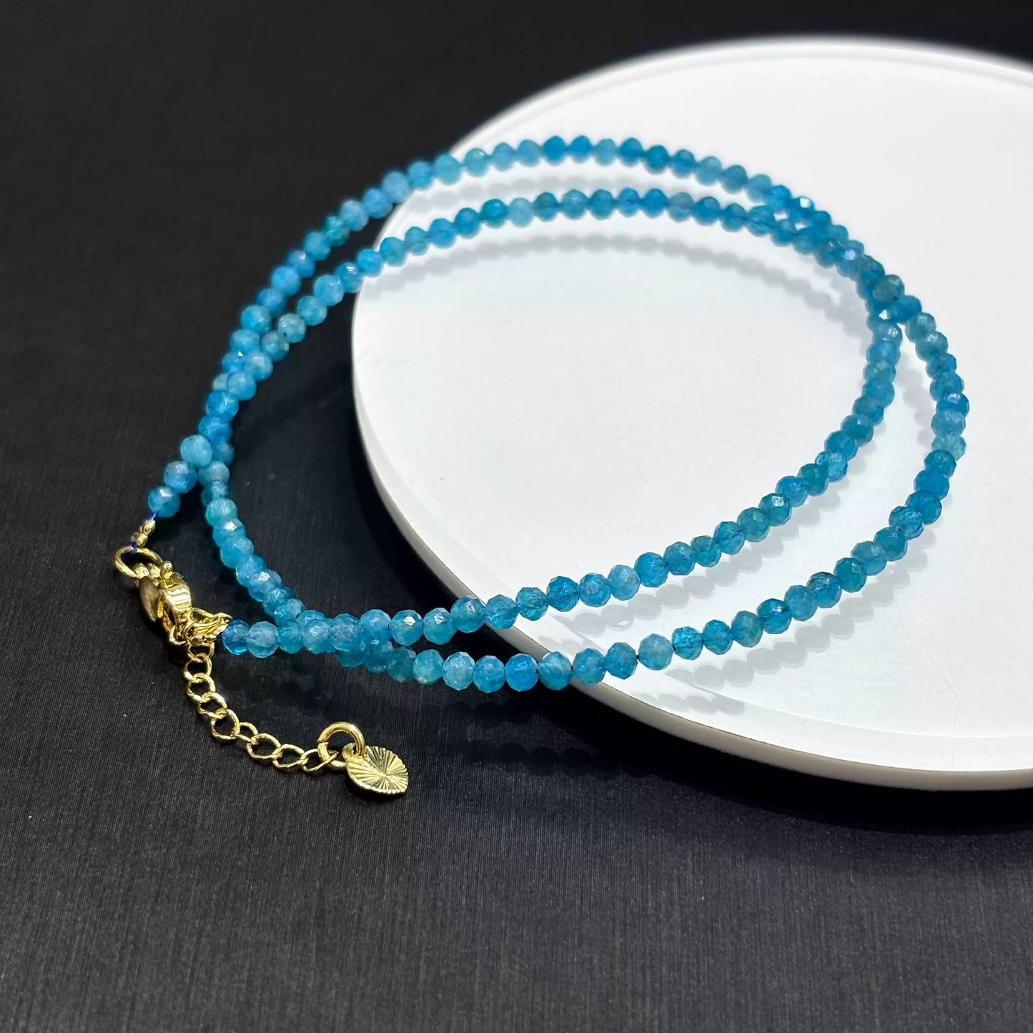 Blue apatite wrap bracelet showing gold-toned lobster clasp, 5cm extension chain, and heart charm detail