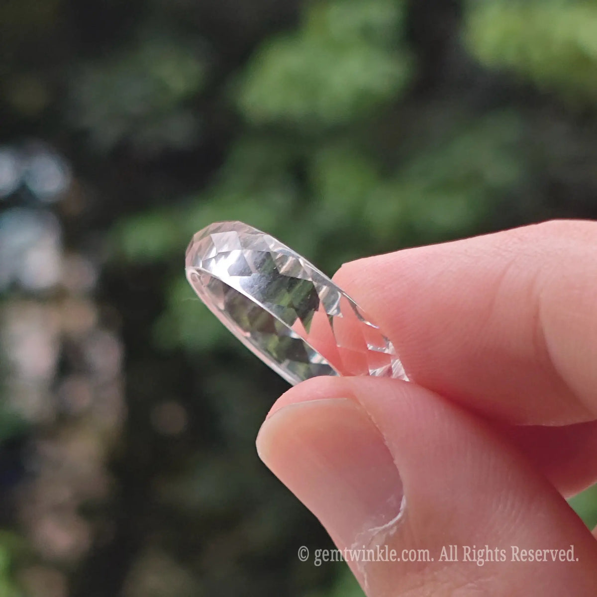Natural clear quartz faceted band ring styled on finger displaying sparkling minimalist fashion jewelry look