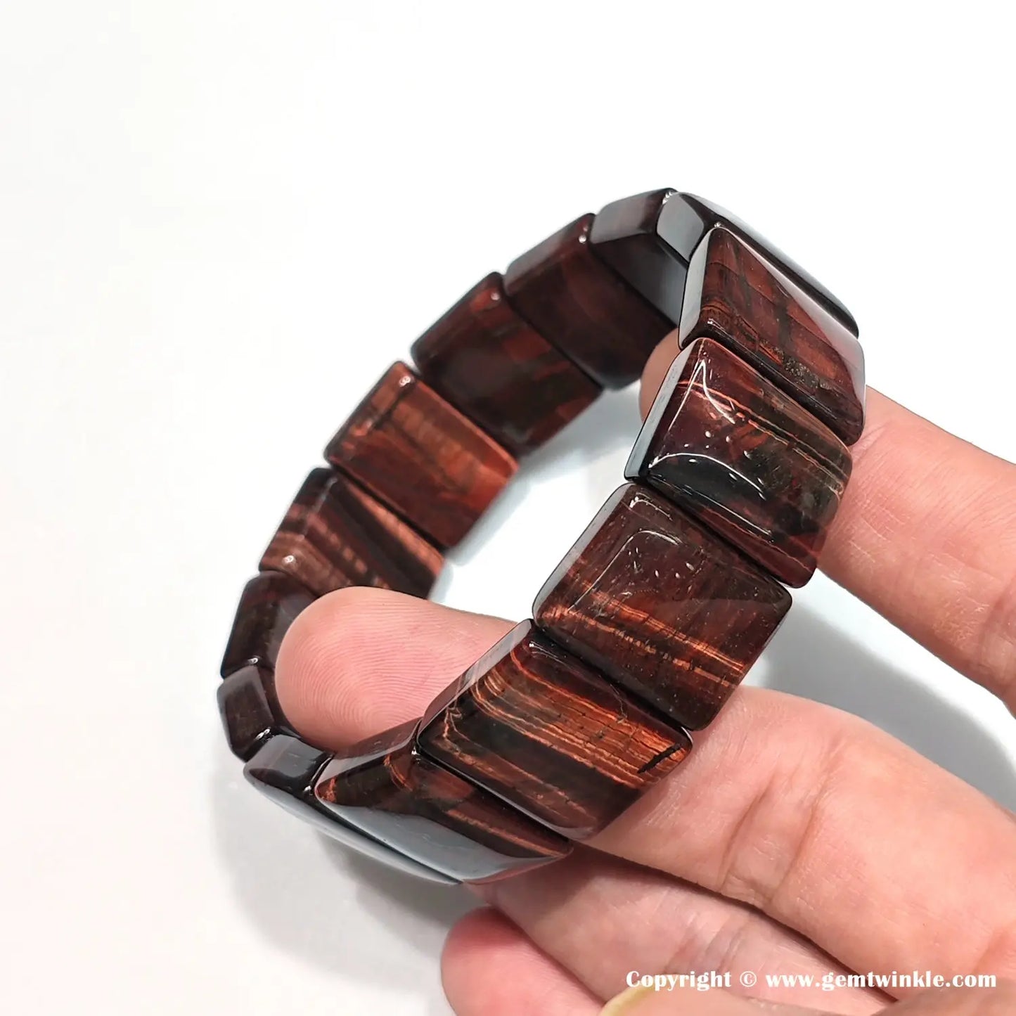 Top-down view of red tiger eye bangle in closed circle, highlighting uniform rectangular bead alignment and consistent deep red-brown color bands
