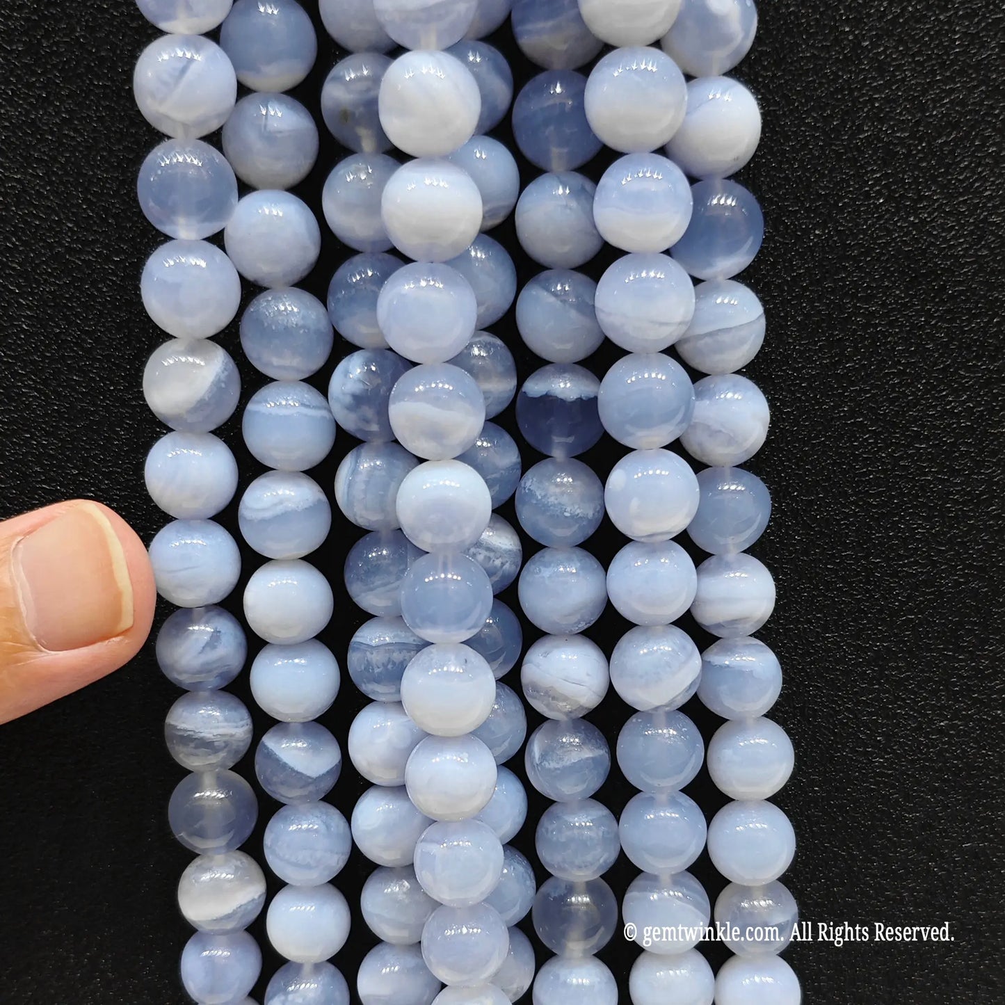 Inspecting a batch of dyed blue chalcedony crystal beads from 10mm to 12mm with natural agate base for store size chart validation