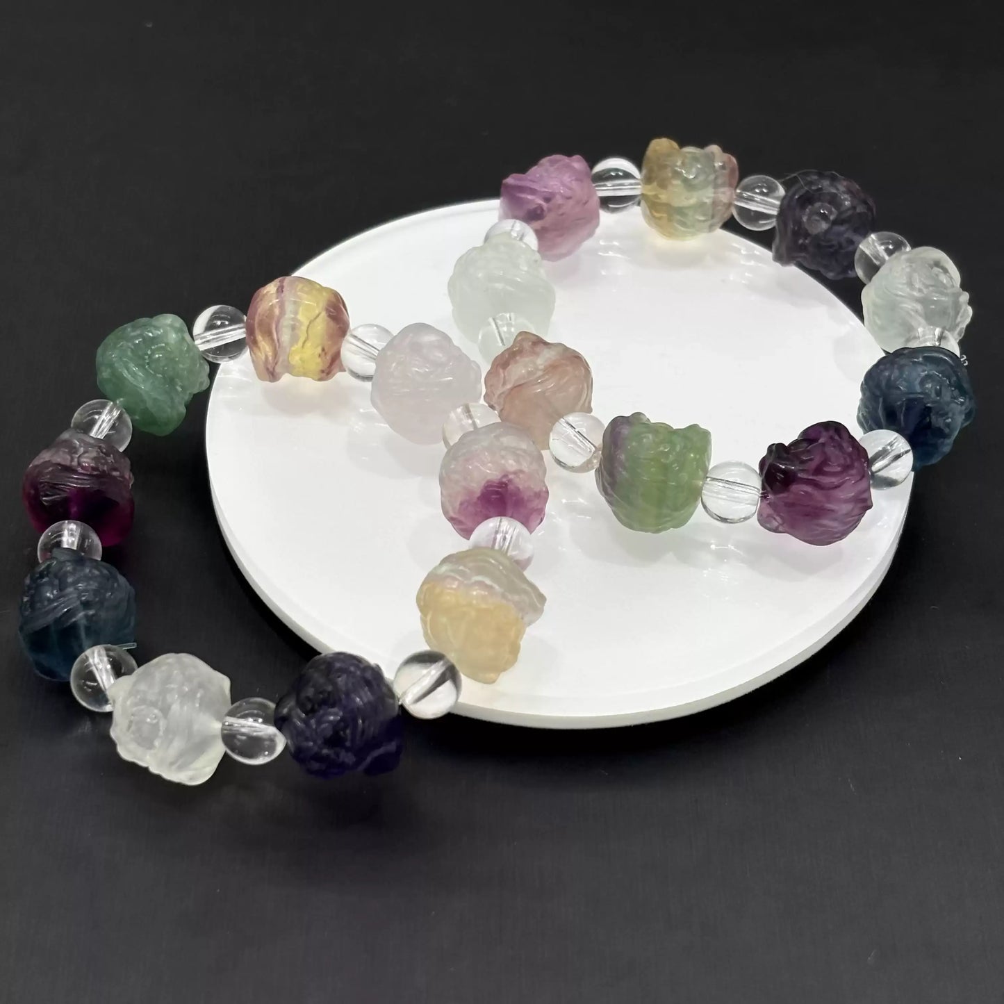 Clean presentation: fluorite lion head beads strung with clear spacers on elastic cord—no metal components