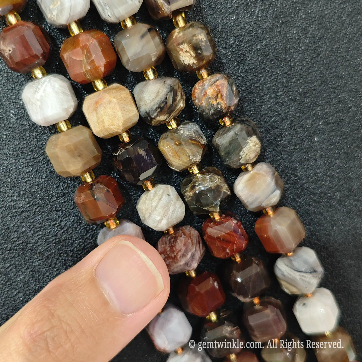 Detailed macro view of natural wood grain jasper geometric cube beads showcasing layered brown and red banding patterns