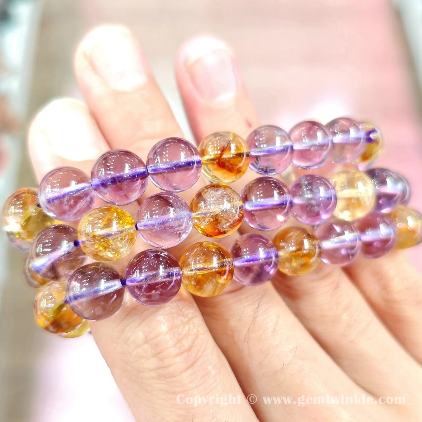 Close up handheld view of 10mm quartz bead surface polish and purple-yellow color contrast