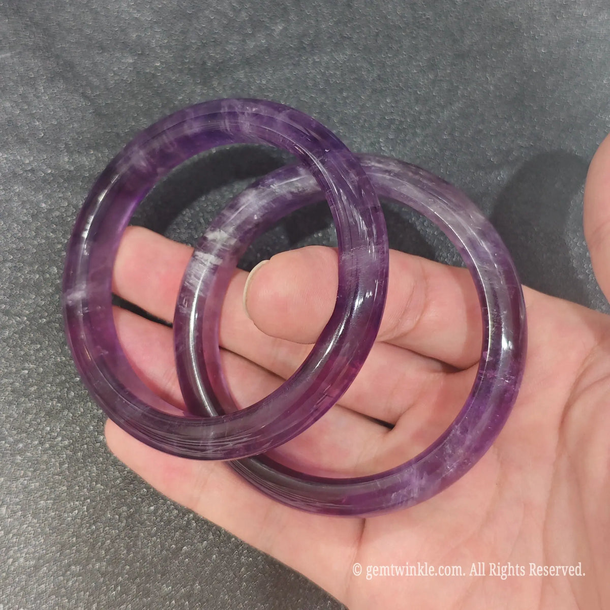 Detailed macro view of smooth carved Amethyst gemstone bangle highlighting polish quality and mineral translucency
