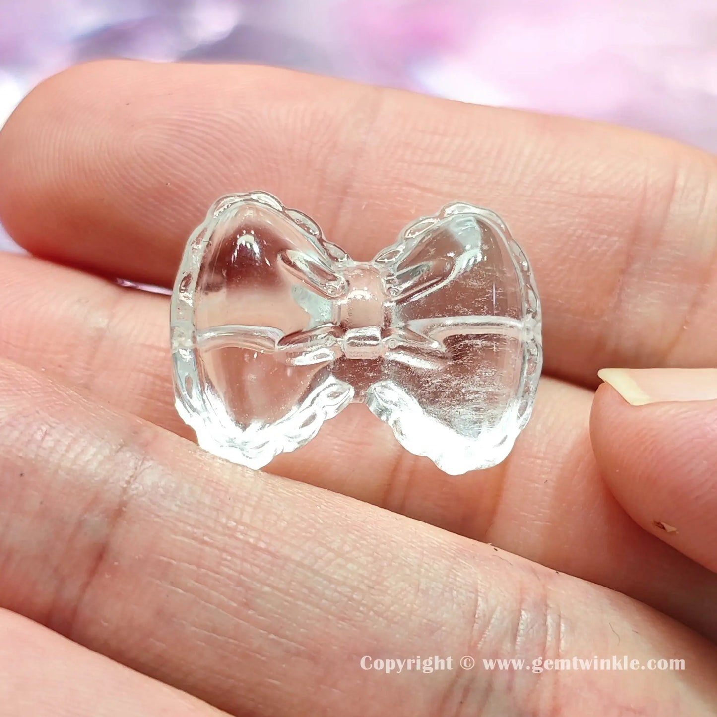 Front view of authentic translucent quartz bowknot bead displaying 17mm and 24mm size proportions on fingers