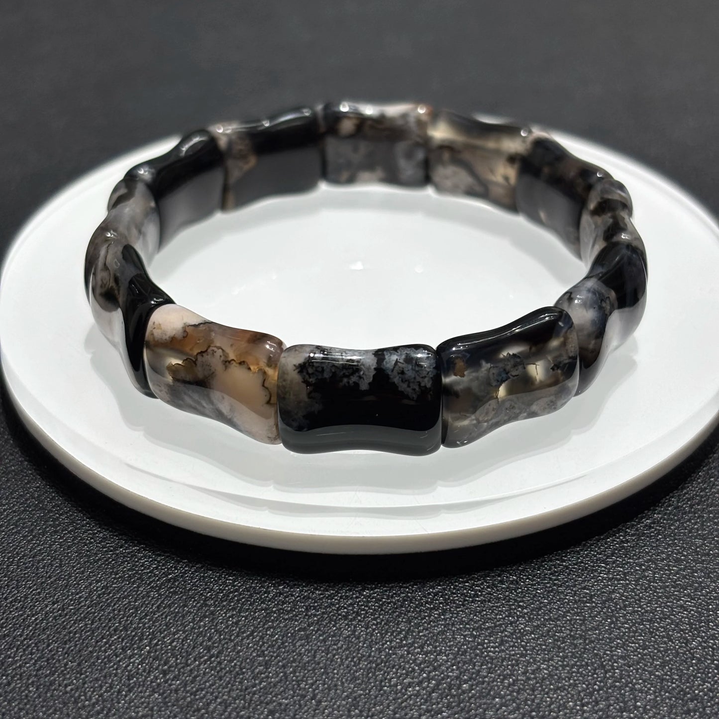 Lifestyle Photo of Black Sakura Agate Bamboo Bangle on Table