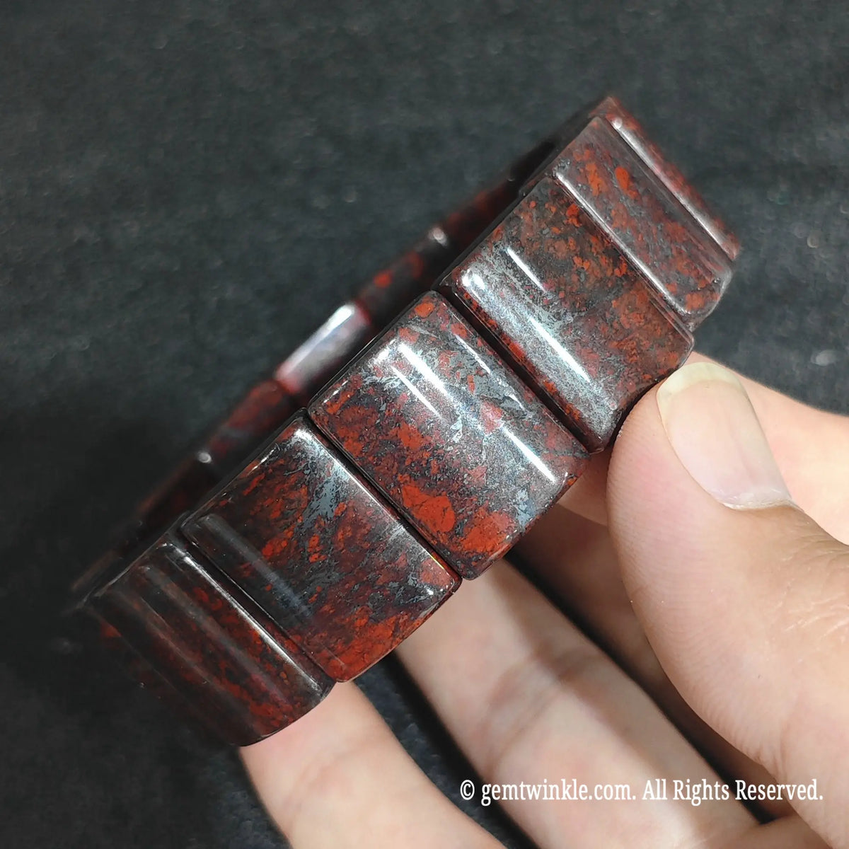Macro close-up showing the deep green chalcedony matrix and vibrant crimson red jasper splatters on bloodstone blocks