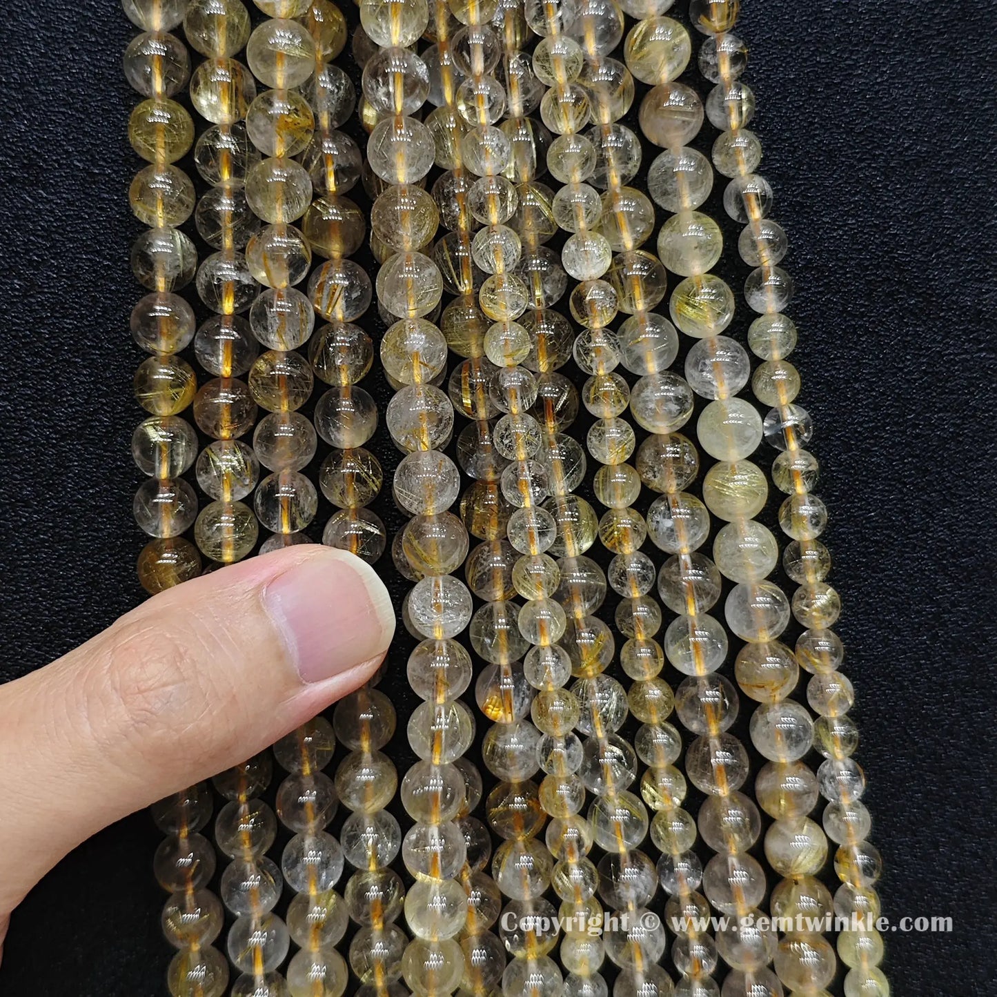 Multiple strands of 8mm golden rutilated quartz loose beads hung together showing raw earth-mined hair alignments for handmade jewelry makers