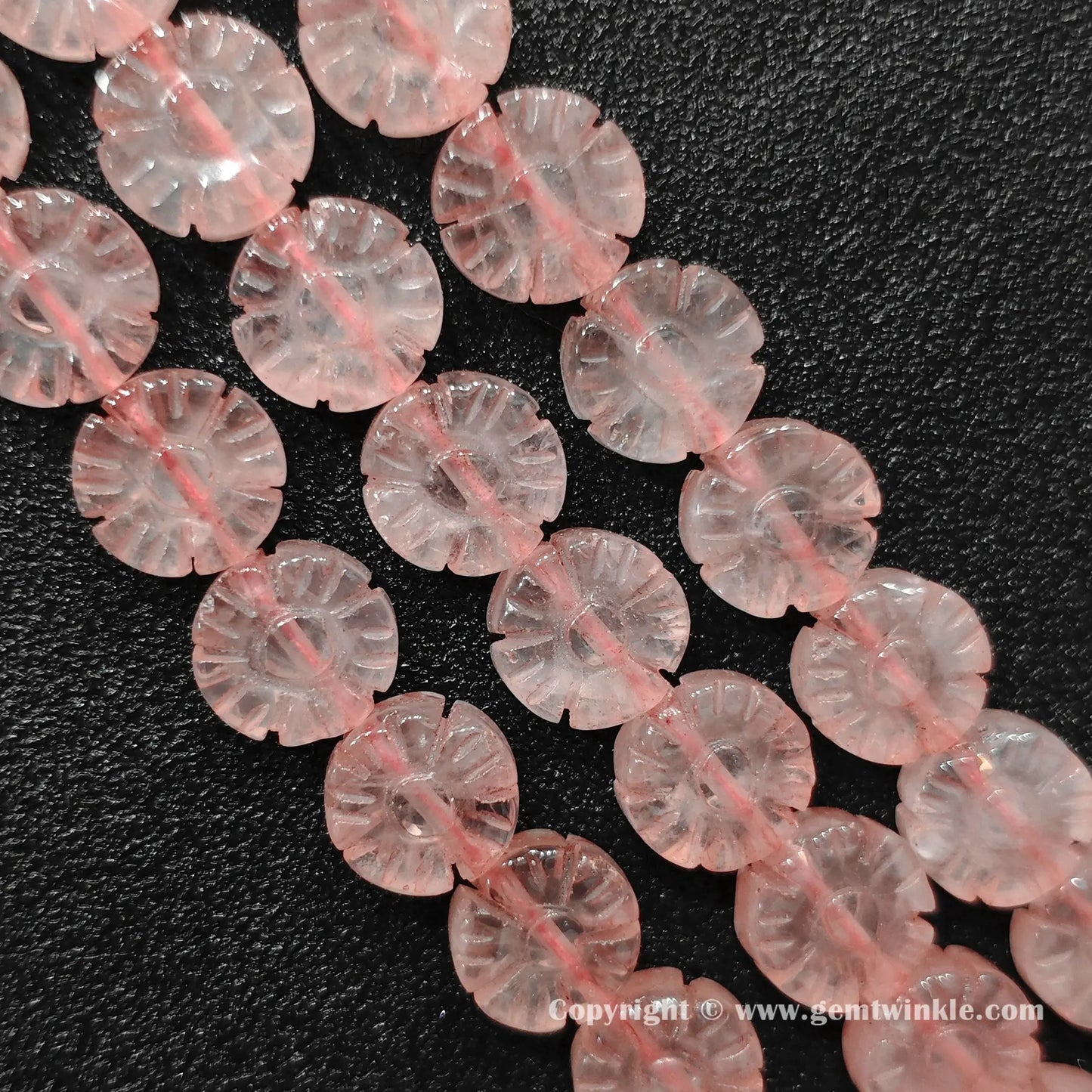 Natural rose quartz plum blossom flower bead strands laid on surface for quality preview