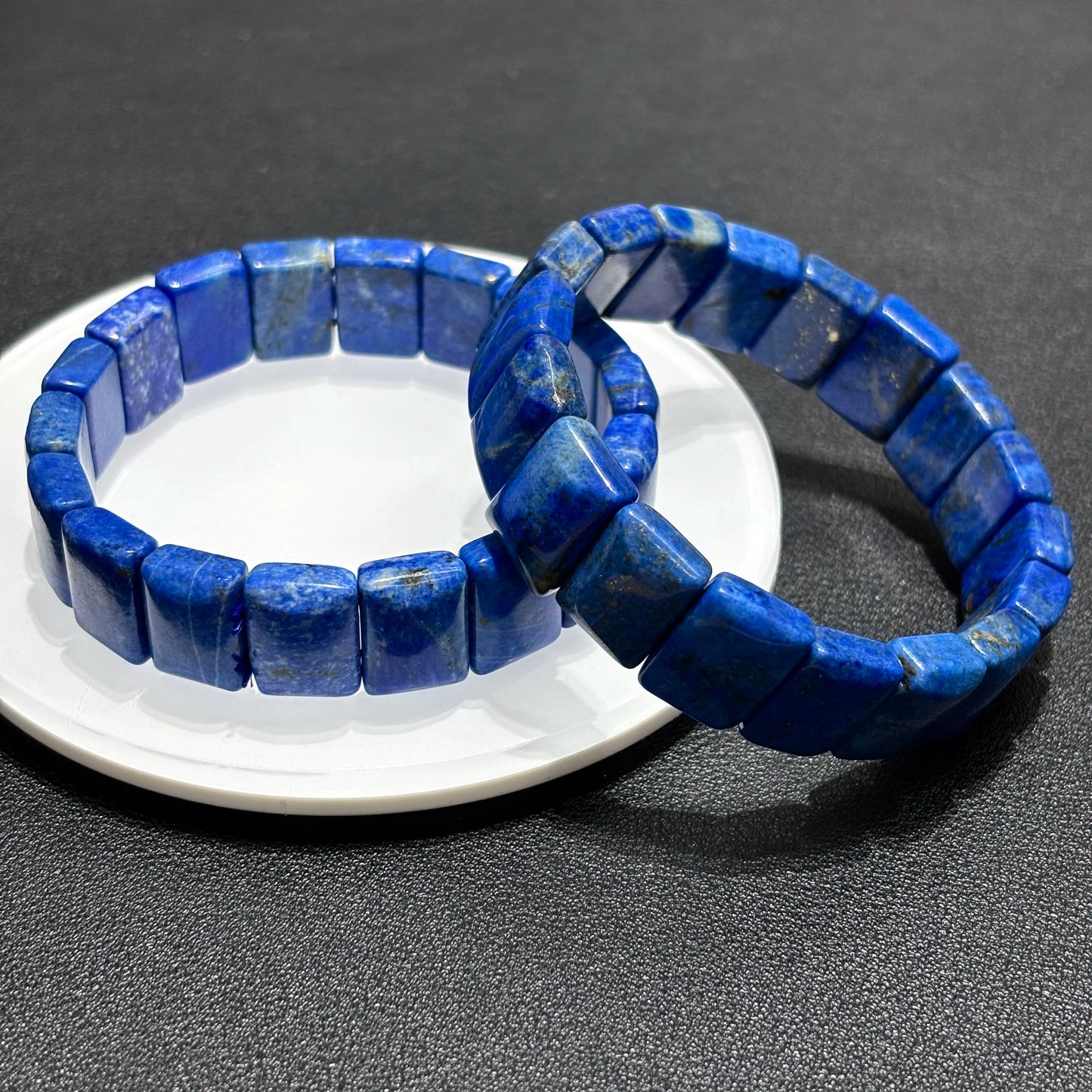 Close-up of a natural lapis lazuli square bead bracelet, showcasing the intricate details and natural patterns of the blue stones.