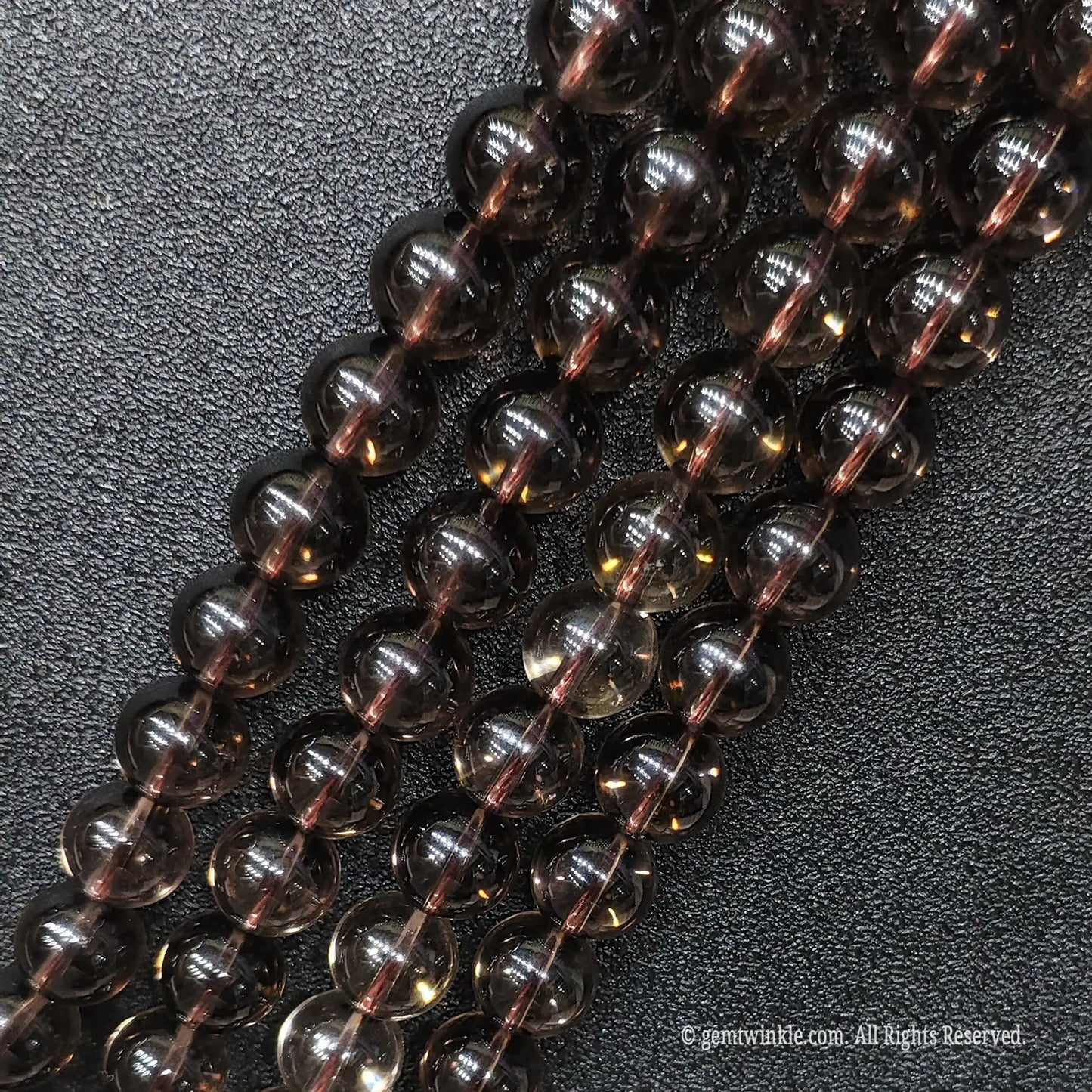 Close up of eyeclean smoky brown crystal gemstone beads showing superior diamond polish and no ice cracks
