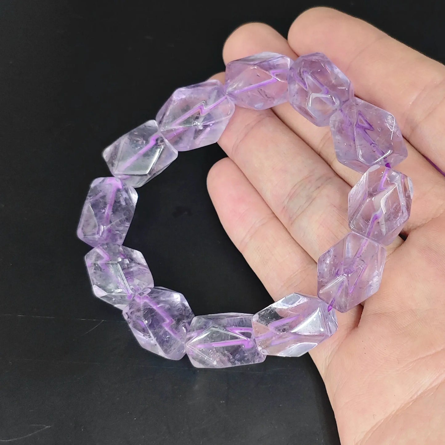 faceted light amethyst freeform bead stretch bracelet displayed in open hand