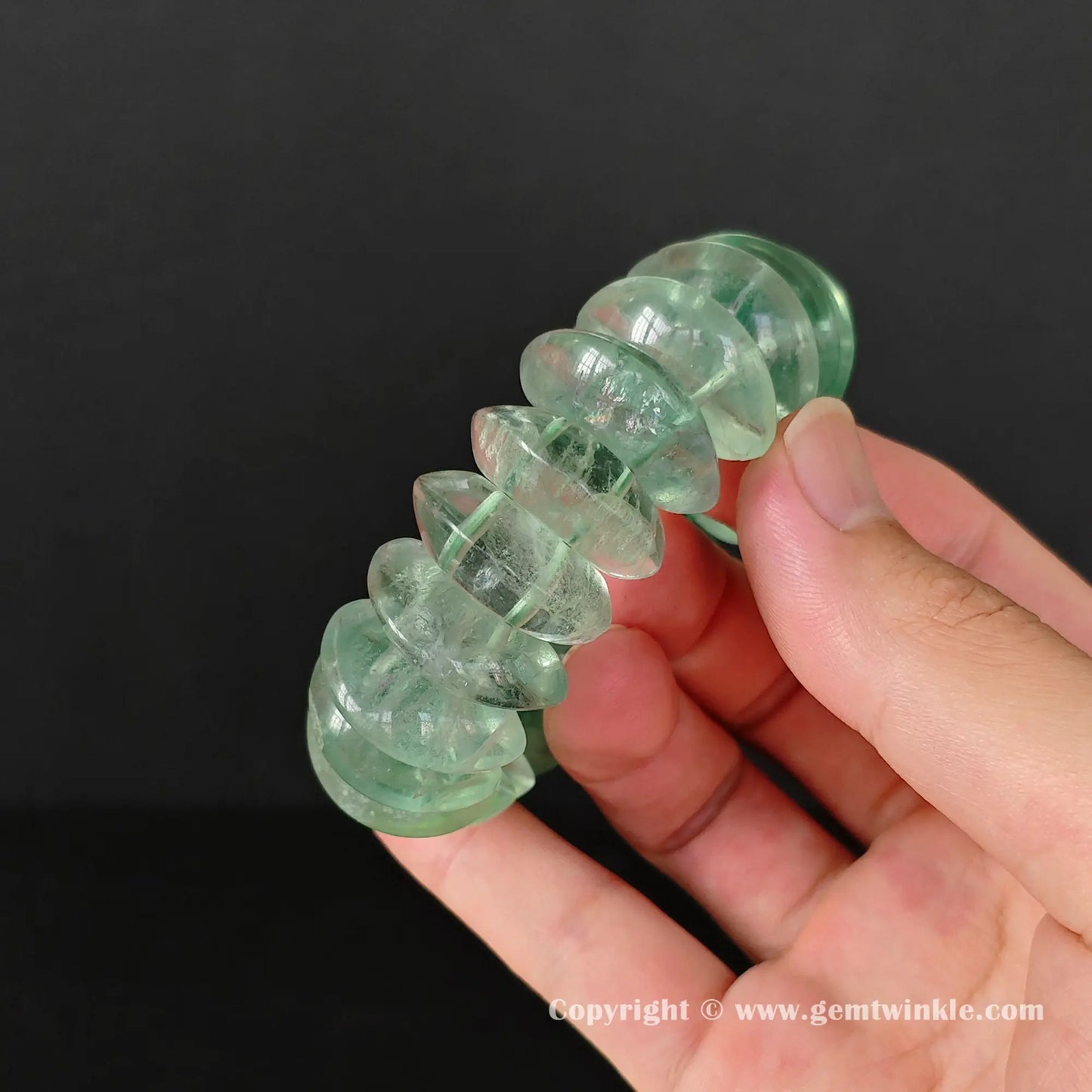 Close up detail of a genuine green fluorite gemstone statement bracelet held vertically