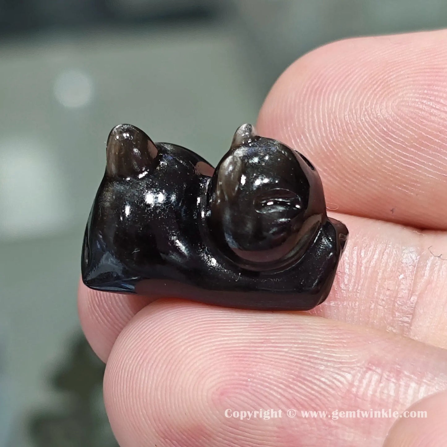 Front view of genuine silver sheen obsidian yoga cat charm bead showing size proportions and drill hole position on hand