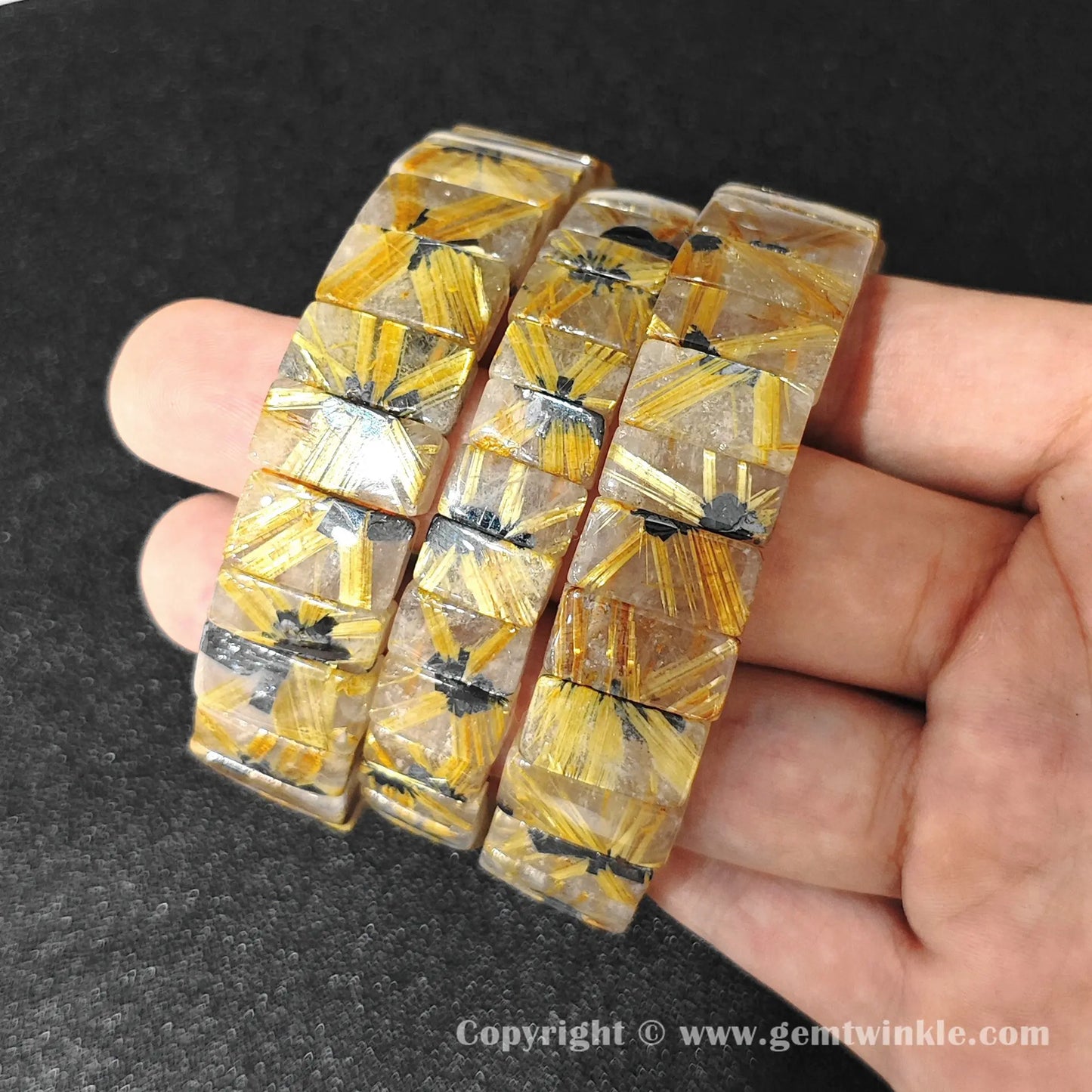 multiple natural golden rutilated quartz plate bracelets displayed together for customer selection