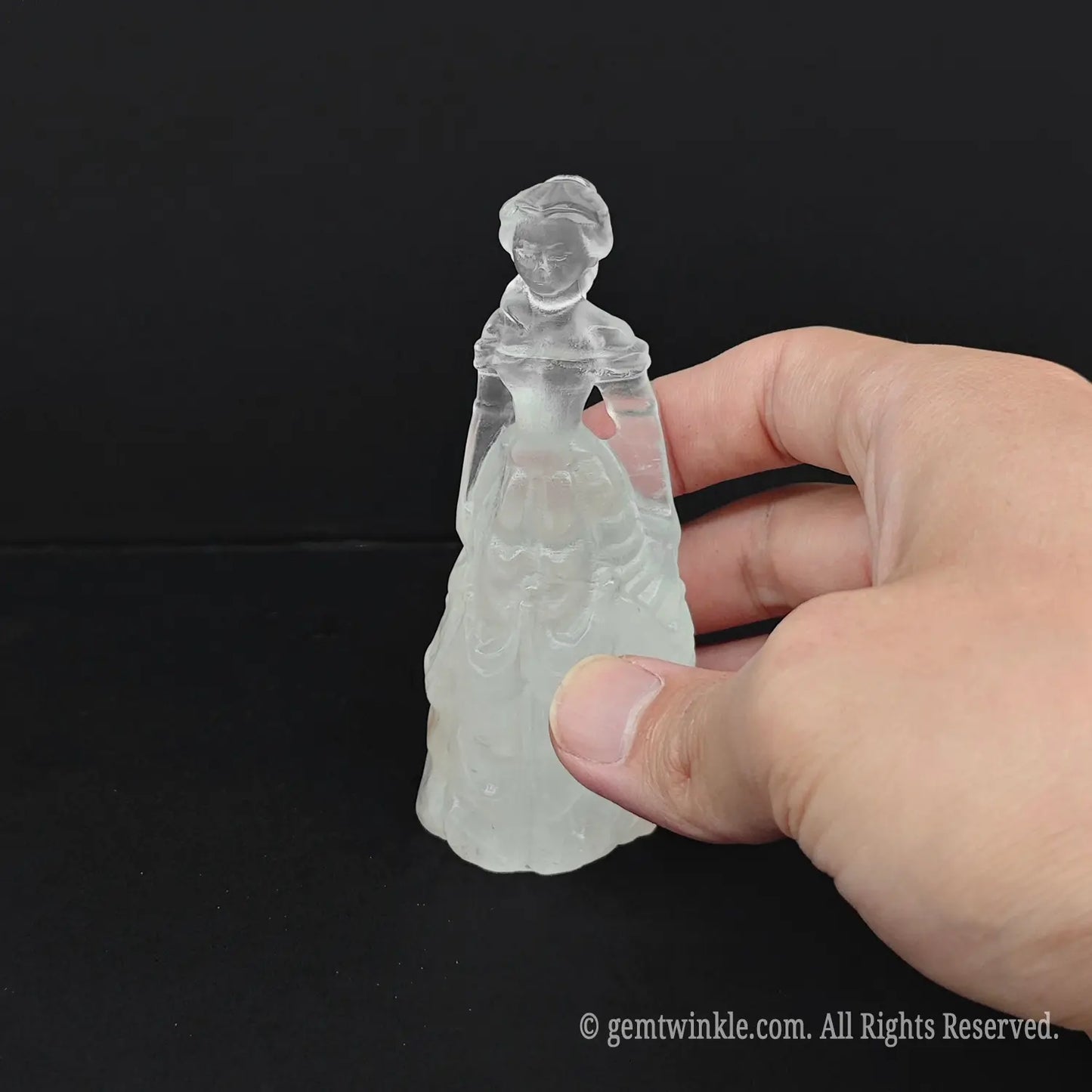Hand holding an approx 10cm (4 inches) natural milky quartz princess statue to display its dense white color and actual size for wholesale buyers