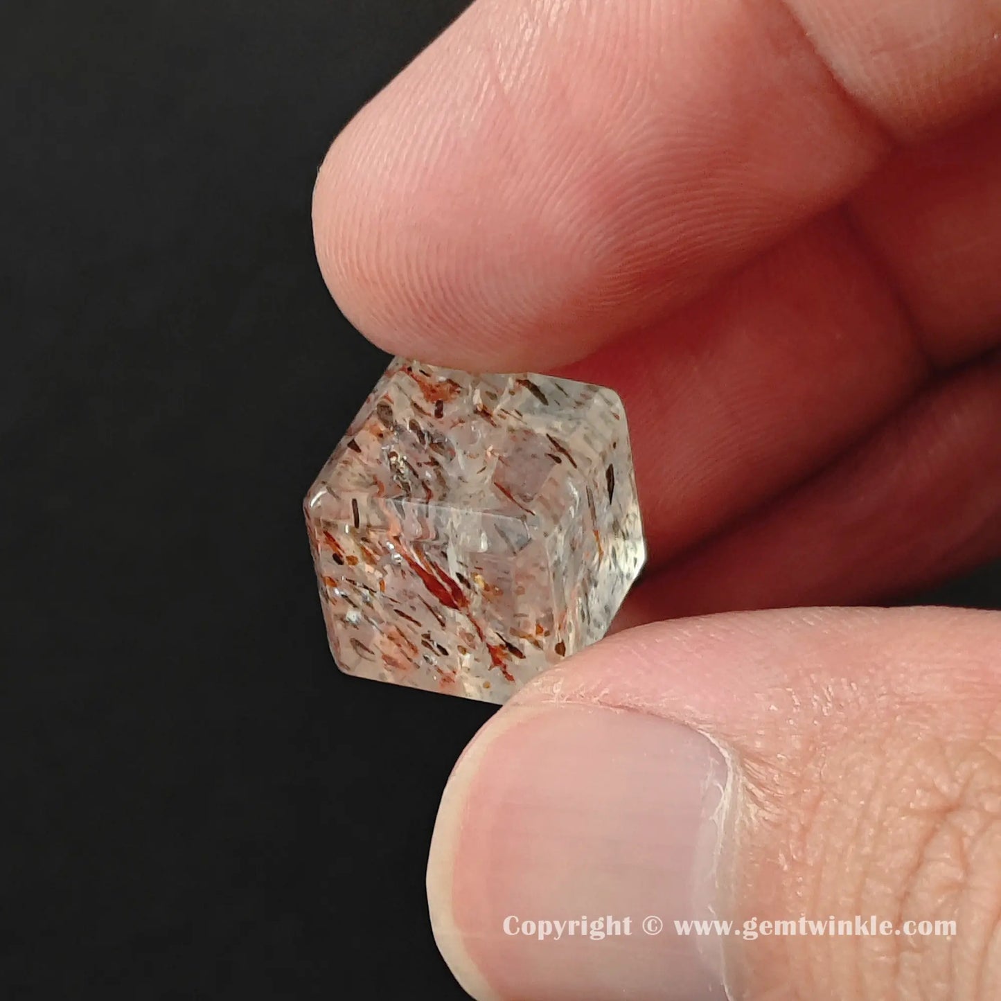 Close up of natural mineral inclusions inside a black gold super seven cube bead for jewelry making