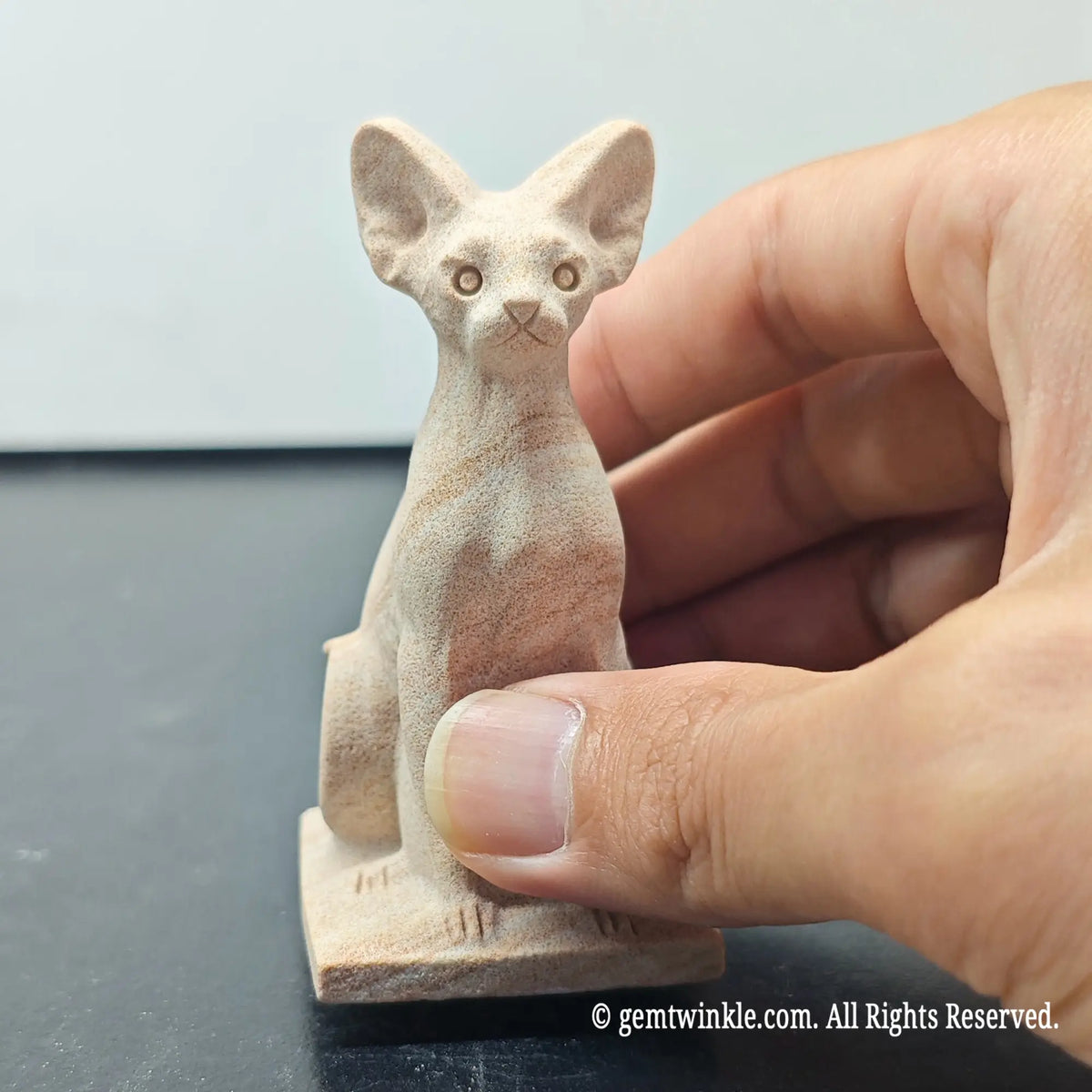 front view of natural sandstone egyptian bastet cat figurine displaying alert ears and facial features