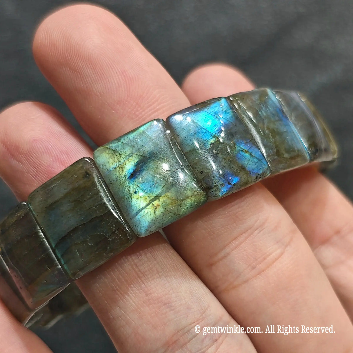 Full view of a stacked unisex labradorite gemstone wristband worn on wrist under studio light