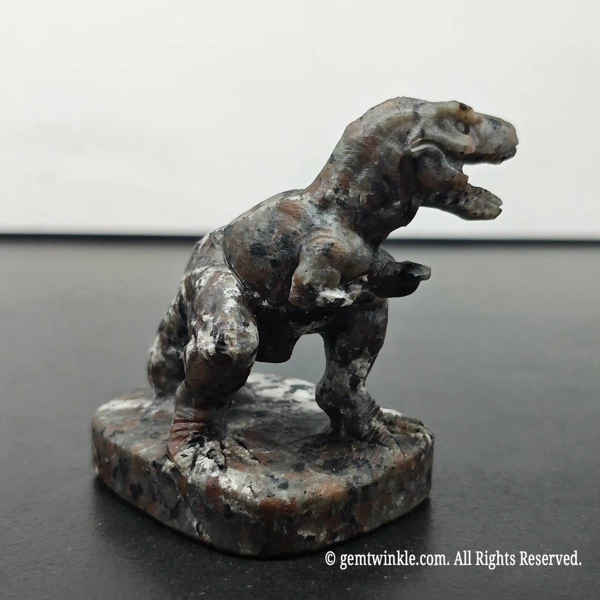right side perspective view of carved t-rex dinosaur statue under daylight displaying base details and stone grain