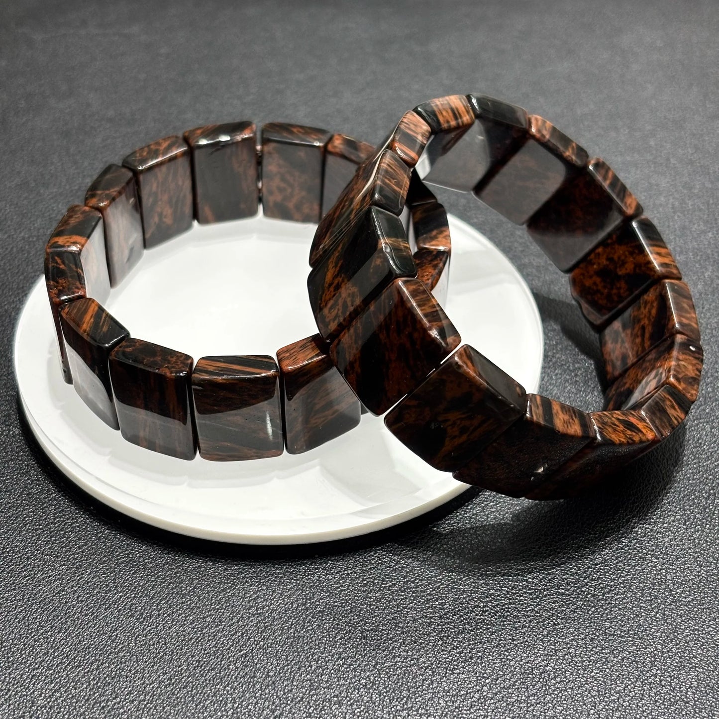 Close Up of Two Mahogany Obsidian Bangle Bracelets on White Plate, 20x14mm Rectangular Beads, Vintage Fashion Accessory