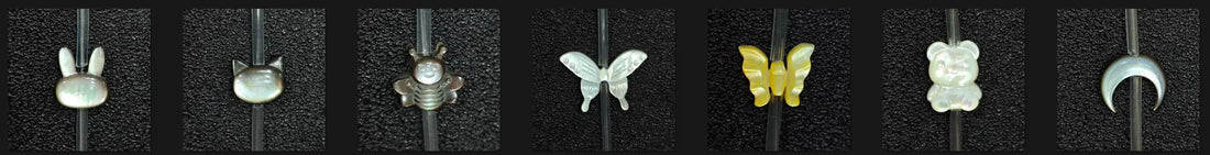 Assortment of precision-carved Mother of Pearl shell charms including bunny, cat, bee, butterfly, bear, and crescent moon shapes for jewelry making