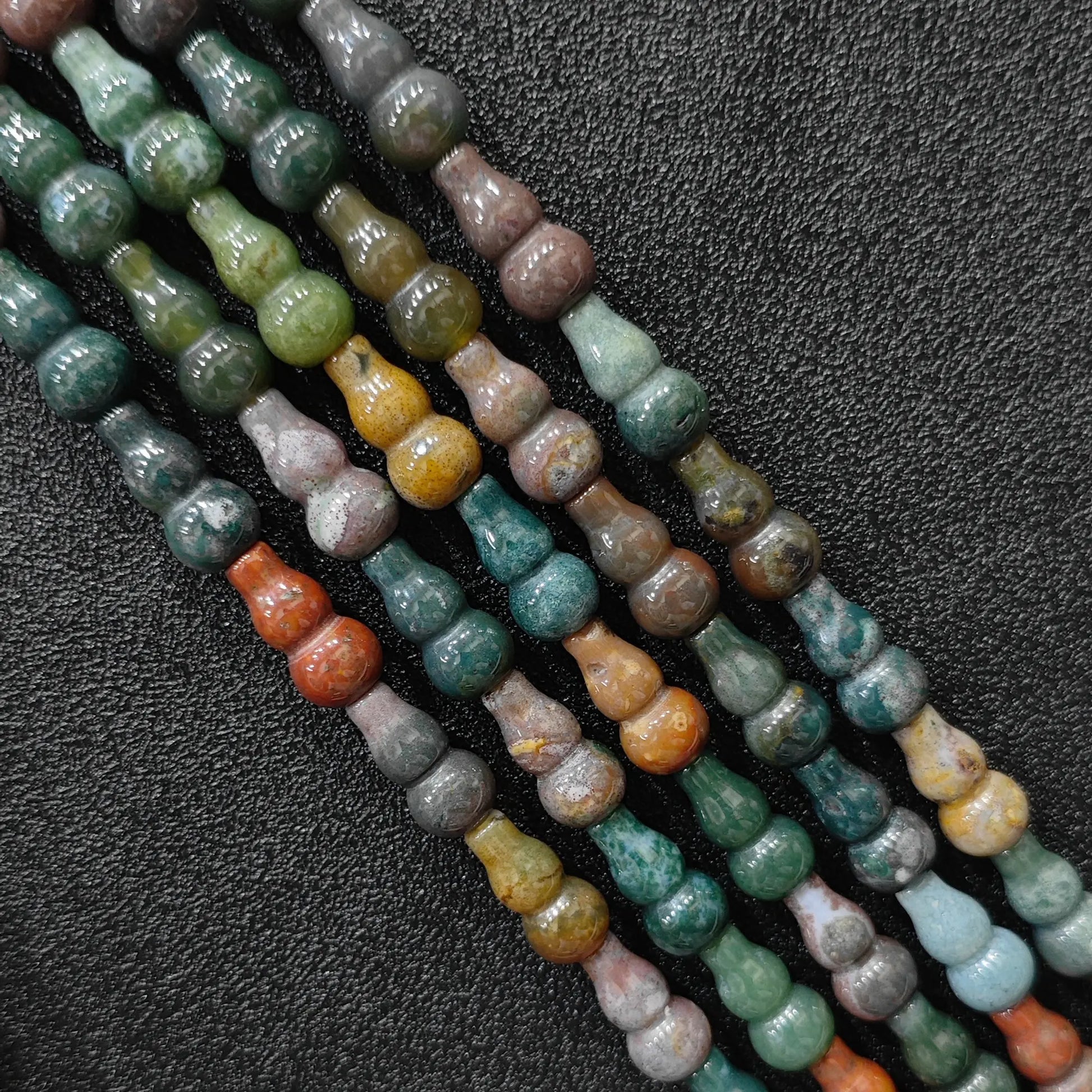 Macro closeup of 16x8mm natural ocean jasper calabash cut beads showing organic orbicular patterns