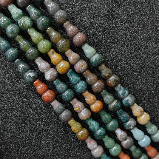 Macro closeup of 16x8mm natural ocean jasper calabash cut beads showing organic orbicular patterns
