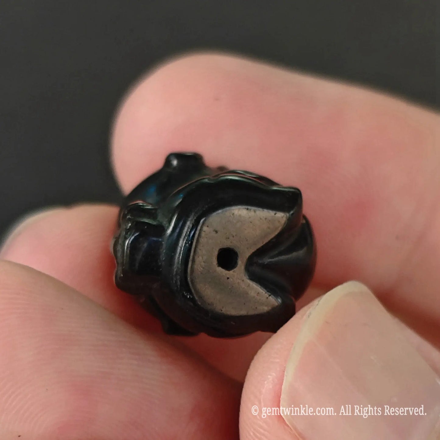 Natural 20mm obsidian astronaut bead top view showing vertical drill hole for jewelry stringing and cord insertion