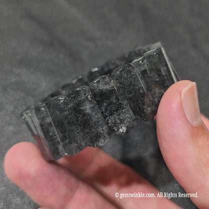 Close up view of 20x9mm black mica quartz plate beads showing smooth polish and dark geometric bead style