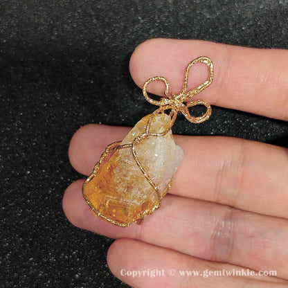 Handheld perspective of 30mm heat-altered citrine rough crystal wire wrapped component