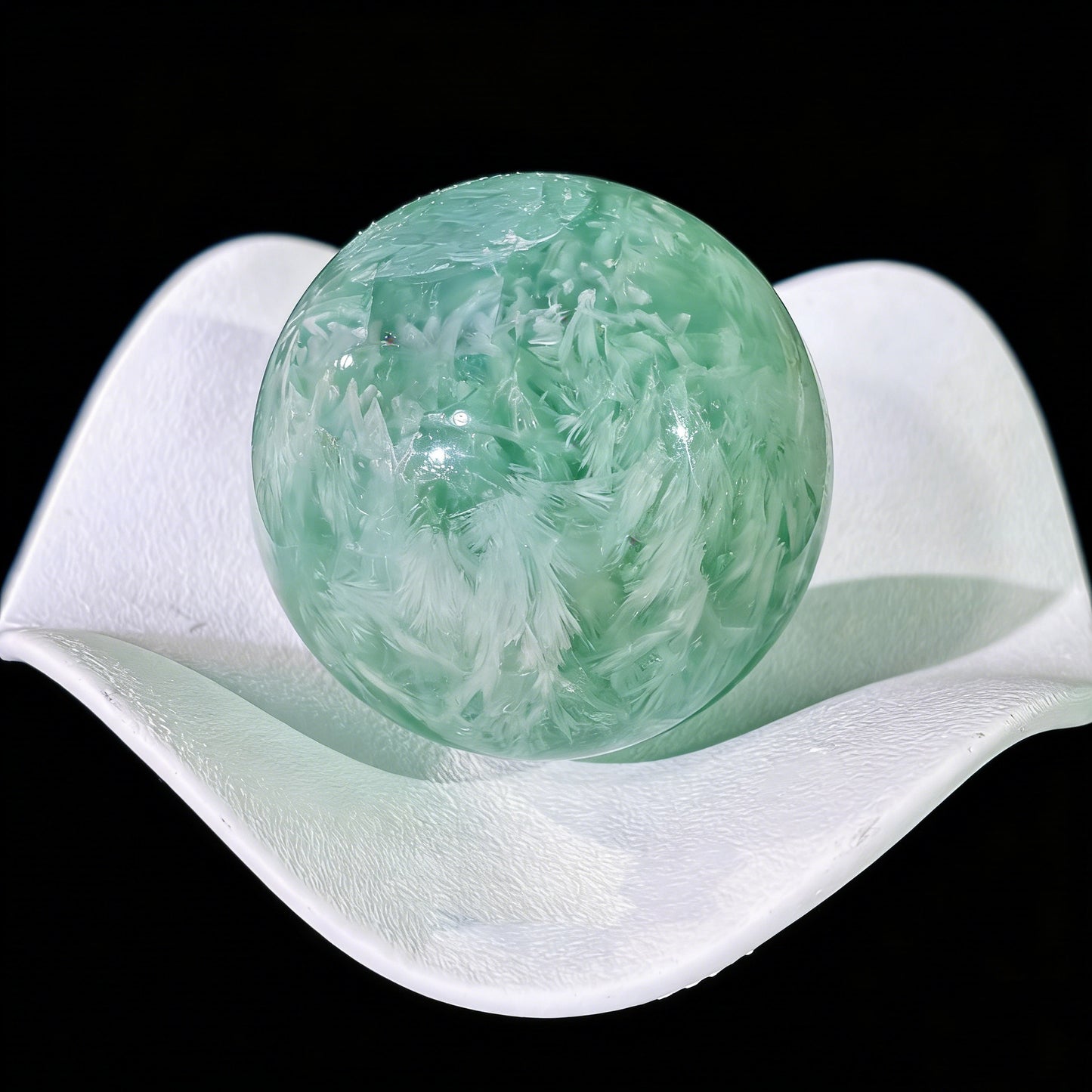 Green fluorite sphere rotated to display natural white feather inclusion pattern from all angles