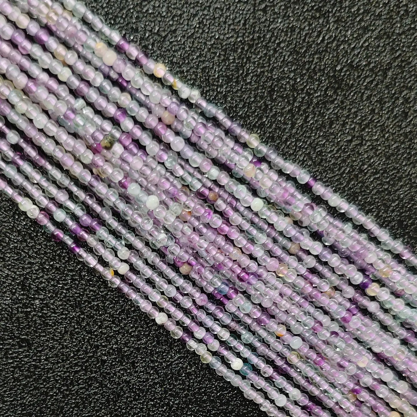 Close up of 3mm lavender purple fluorite beads micro crystal strands with natural cloudiness
