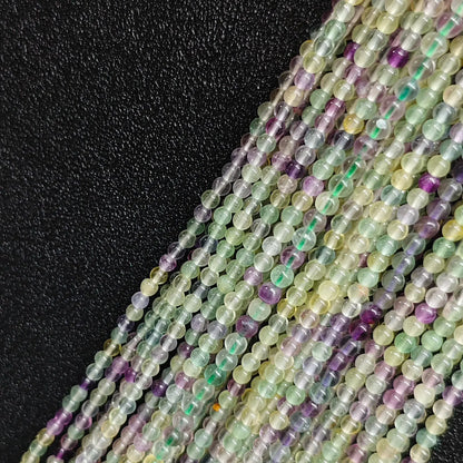 Close up of 3mm rainbow fluorite tiny beads multi color crystal strands with natural veining