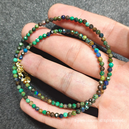 Close up of 3mm micro faceted azurite malachite beads looped on hand highlighting gold extension chain