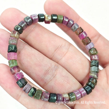 Close up view of natural tourmaline rondelle beads displaying rich magenta, green, and dark mineral tones