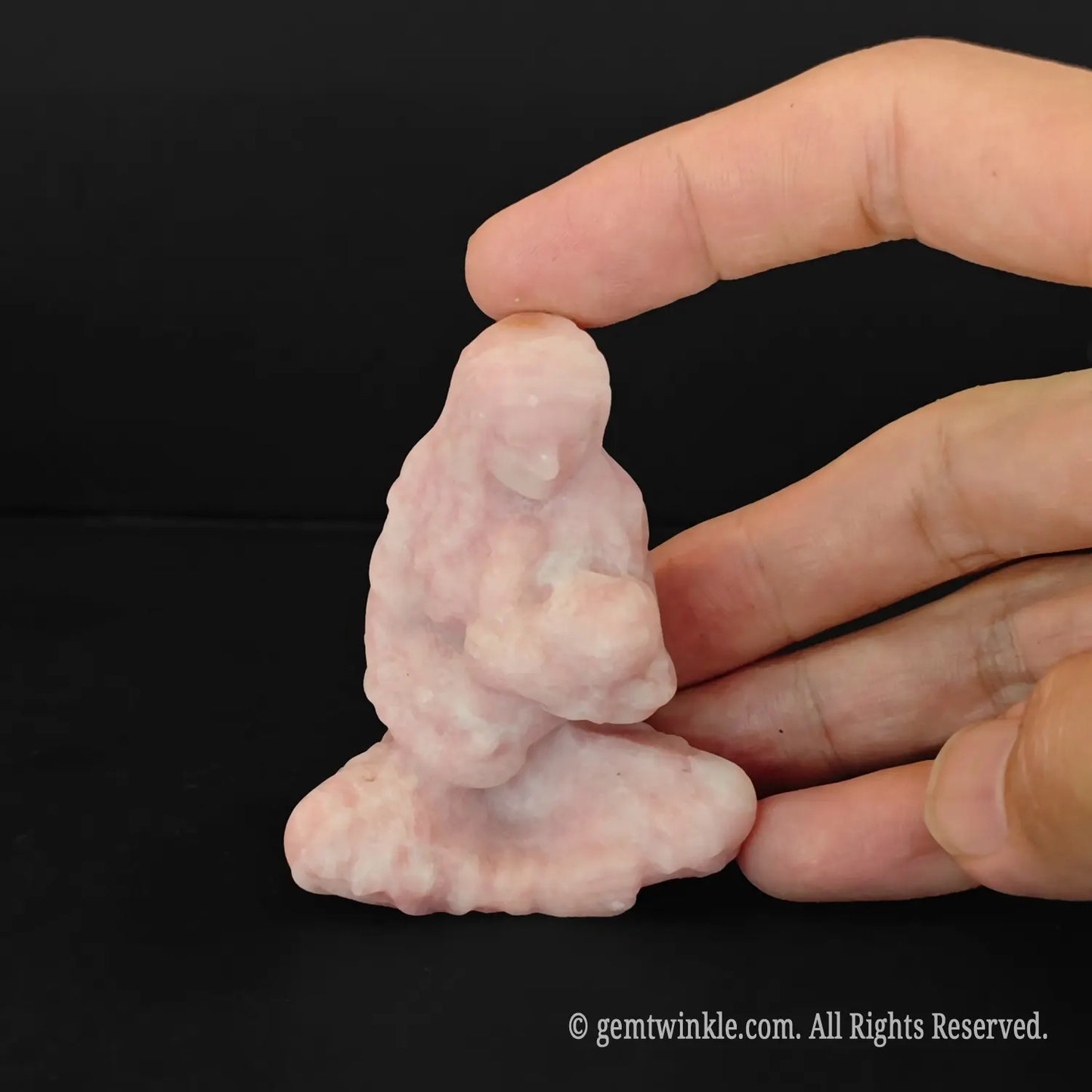 hand holding a tiny six centimeter pastel pink opal virgin mary and baby jesus gemstone statue