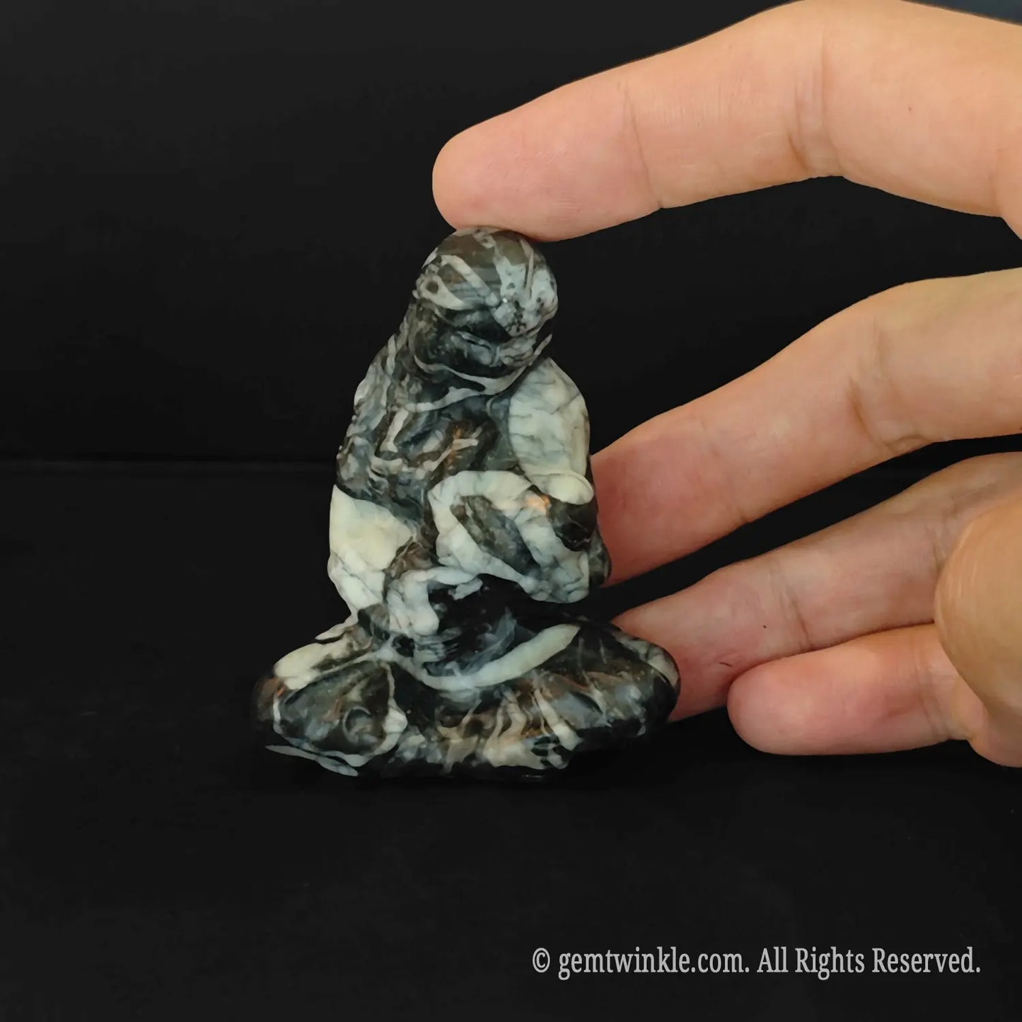 six centimeter zebra stone statue showing a seated mother holding an infant with unique textures