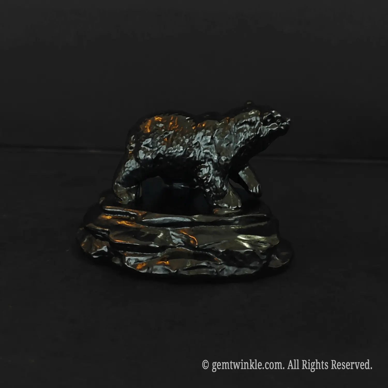 side profile of a glossy black obsidian bear statue showing thick fur texture details