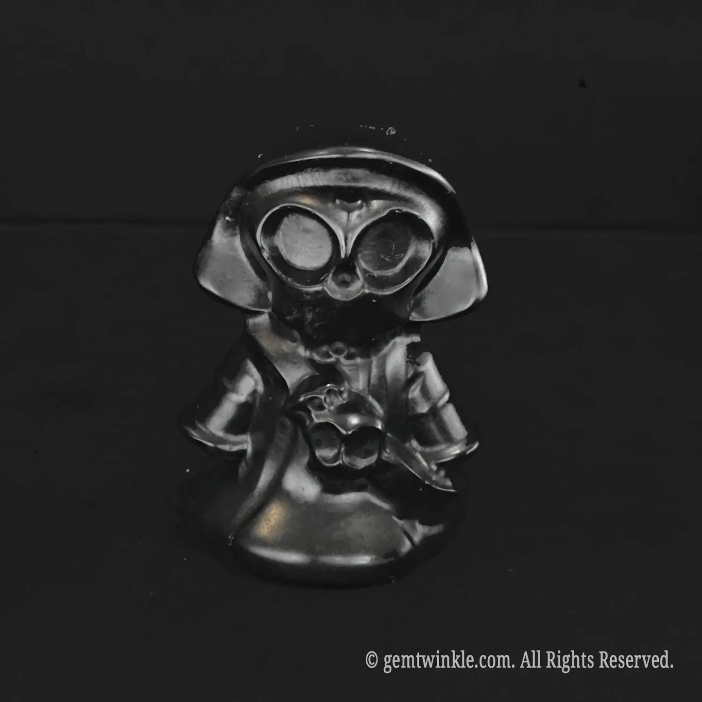 A standalone black obsidian chibi grim reaper carving featuring high reflective shine and detailed hollowed skull eyes