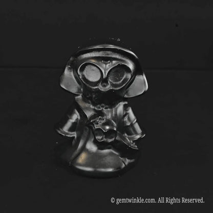 A standalone black obsidian chibi grim reaper carving featuring high reflective shine and detailed hollowed skull eyes