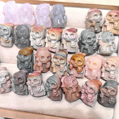 Display tray filled with multiple natural Alxa agate hooded grim reaper mini statues in varied natural earth tones