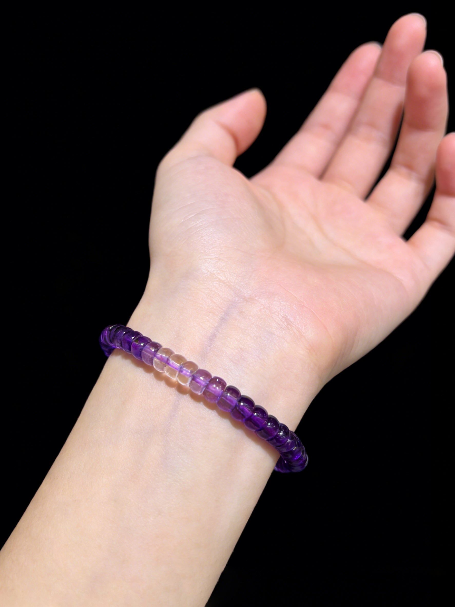 Woman wearing a natural amethyst disc bead bracelet on wrist; minimalist purple gemstone jewelry for daily wear and self-love gifting