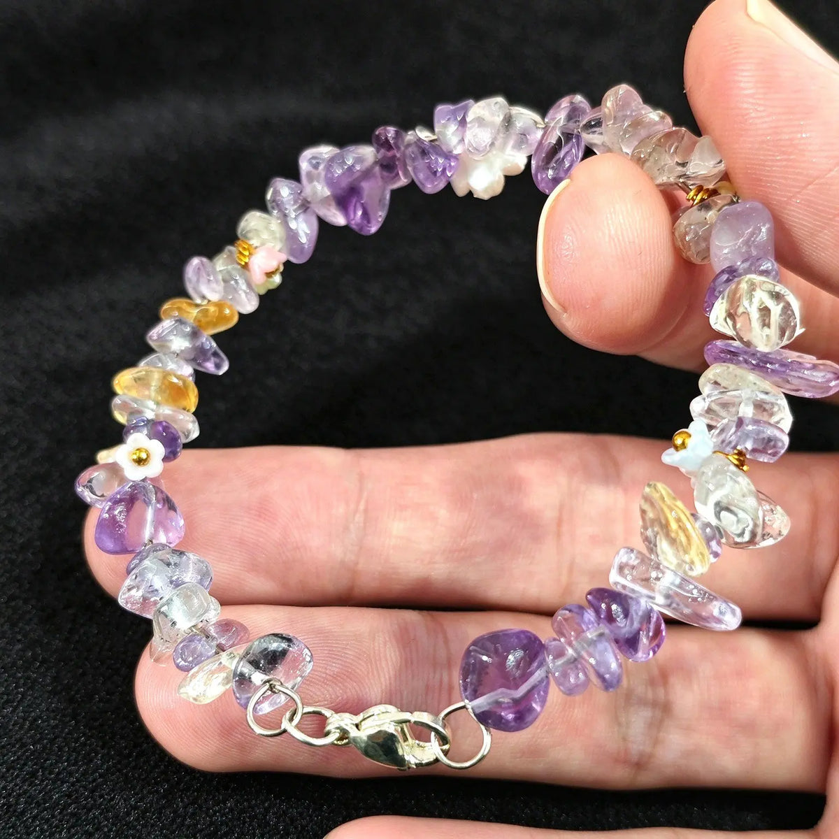 Side view of a handcrafted amethyst and heat treated citrine chip stone bracelet strung on metal jewelry wire