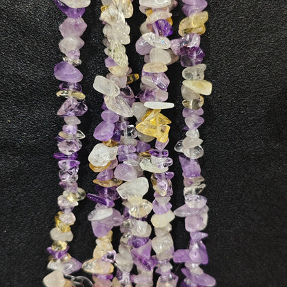 Close up of multi strands of natural amethyst and heat-enhanced citrine mixed 5-10mm irregular chips