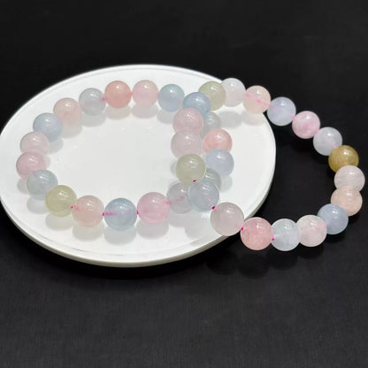 Morganite bracelet arranged in overlapping circles on white dish, highlighting bead uniformity and gentle color gradient.