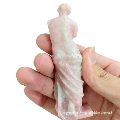 Back view of natural pink opal Venus statue in hand showing polished hair details and natural mineral textures
