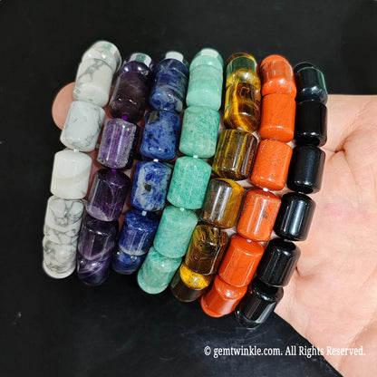 Assorted Chakra Stone Barrel Bead Strands Close Up on Hand